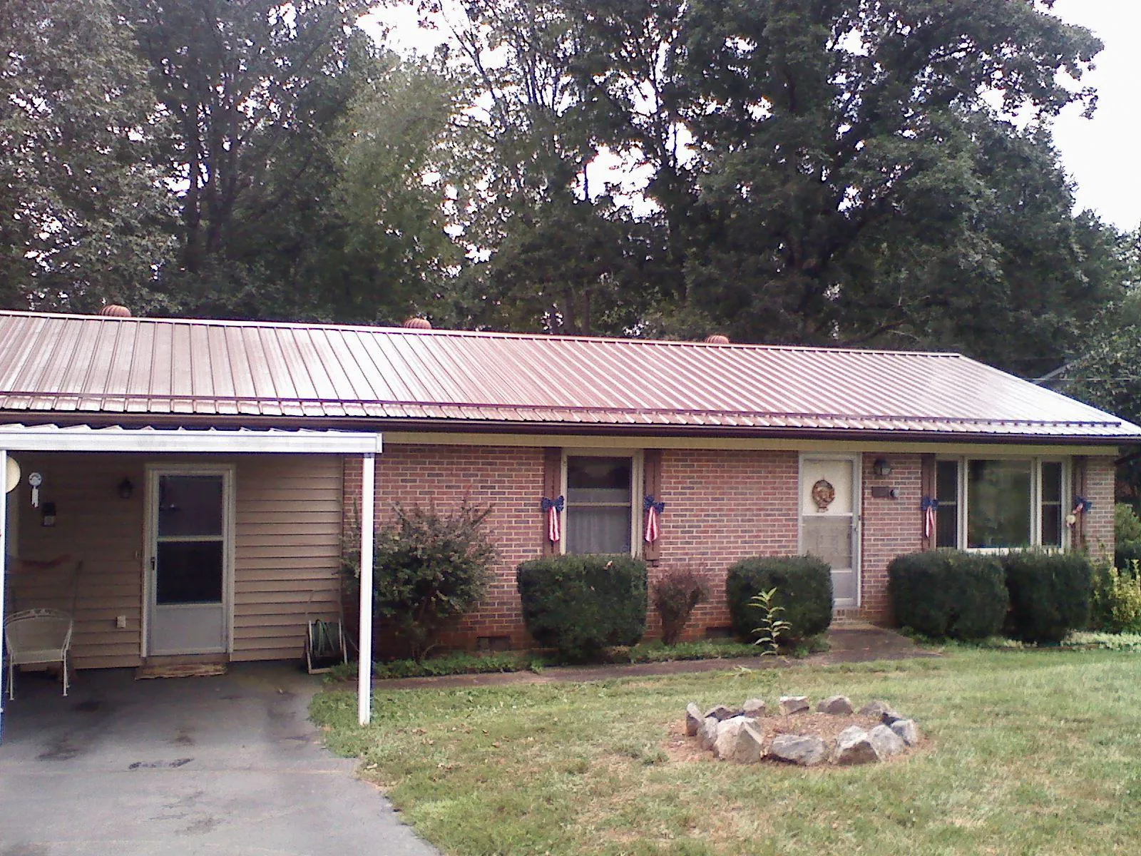 Bronze metal roof and carport on a brick ranch home — Roof Repair work by our crew in Greenport